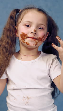 girl with chocolate plate. little girl eating chocolate plate on table. vertical video