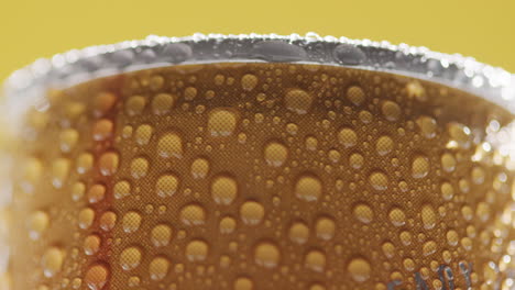 close up of condensation droplets on revolving takeaway can of cold beer or soft drink against yellow background 1