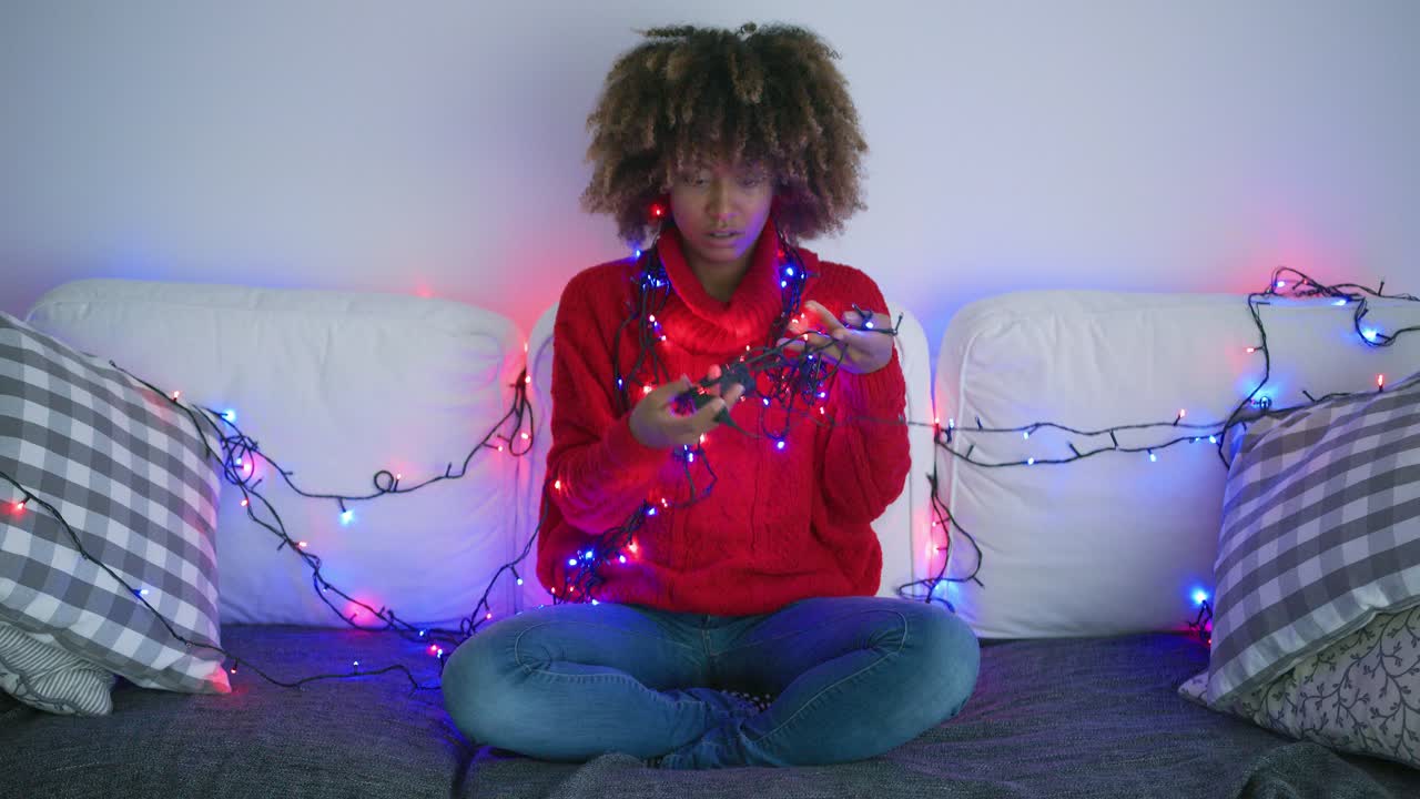 mujer cansada que intenta desenredar la guirnalda