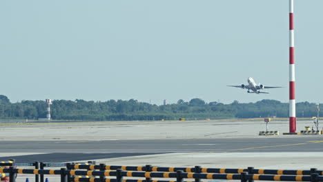 empty airport runway with clear sky and distant trees visible in the background