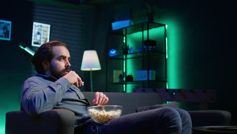 man at home surprise by film ending, unable to believe eyes, dropping popcorn