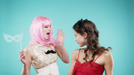 girlfriends dancing wearing red dress and pink hair in slow motion party photo booth