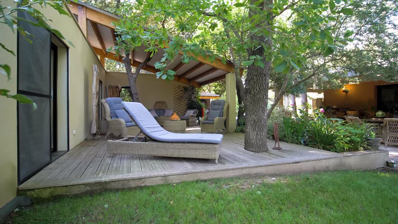 A beautifully arranged garden layout with a balcony featuring leisure chairs, creating a relaxed lounging atmosphere at Maison Vias, France. The setting blends outdoor comfort with tranquil elegance.