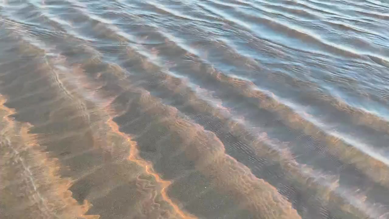 Clear Water Ripples Flowing Over Sandy Beach Shoreline