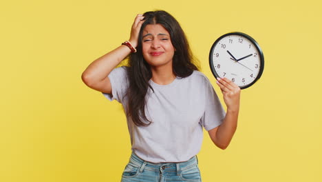 jonge indiase vrouw met angst controleert tijd op de klok, loopt te laat naar het werk in vertraging deadline