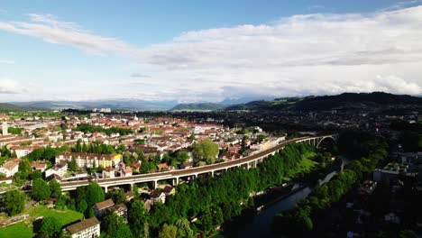 Gorgeous-high-aerial-view-toward-Bern,-Switzerland-with-Swiss-Alps-in-the-distance