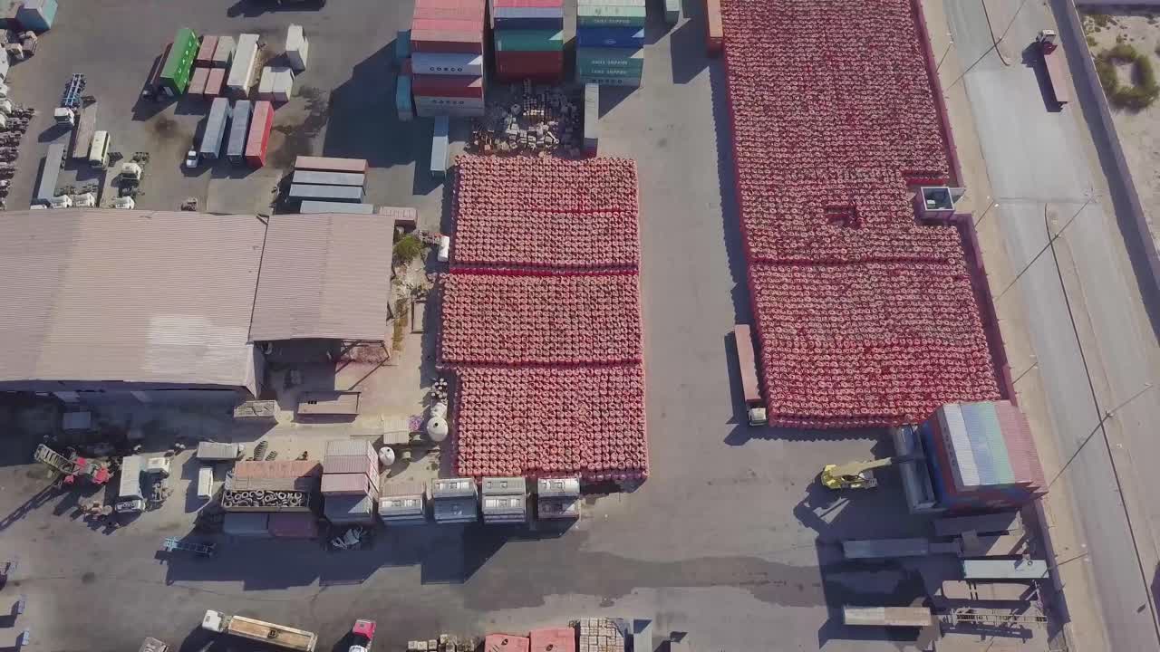 una carretilla elevadora de carga carga un contenedor en la parte trasera de un camión en un gran patio de contenedores