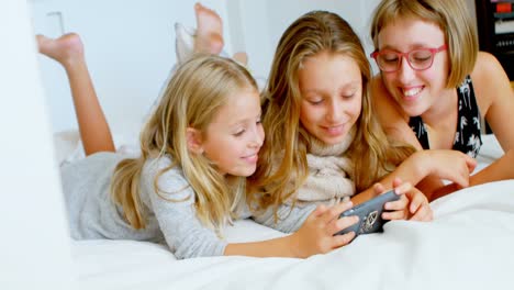 Sisters-using-mobile-phone-on-bed-in-4k
