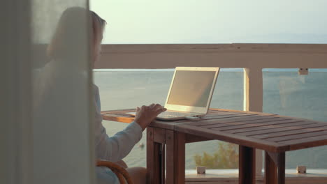 woman browsing on laptop using mobile internet