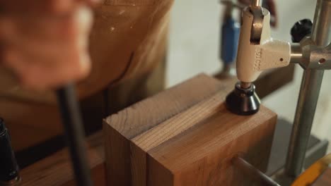 primer plano de un carpintero usando un taladro para trabajar en un trozo de madera