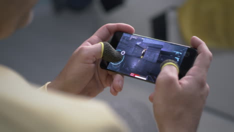 person playing a mobile first-person shooter game