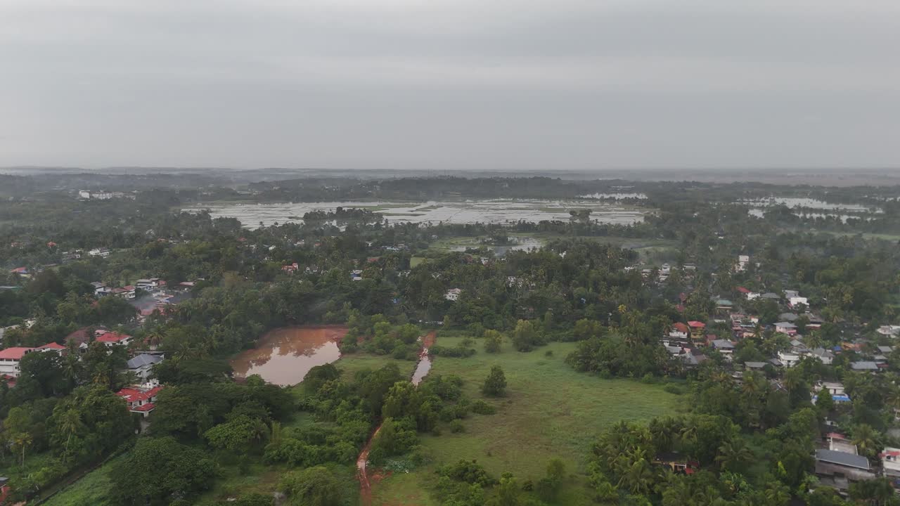 Elevated drone view of a small but growing town, blending modern infrastructure with lush landscapes