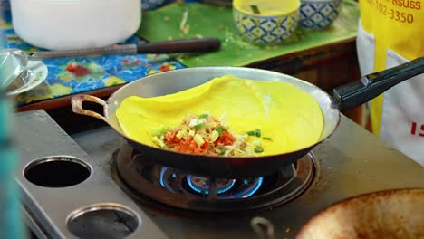 chef prepares pad thai at bangkok's floating market