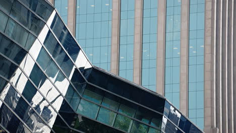 detail close-up of a business buildings with mirror walls on the downtown financial area of a big city with clouds in the back