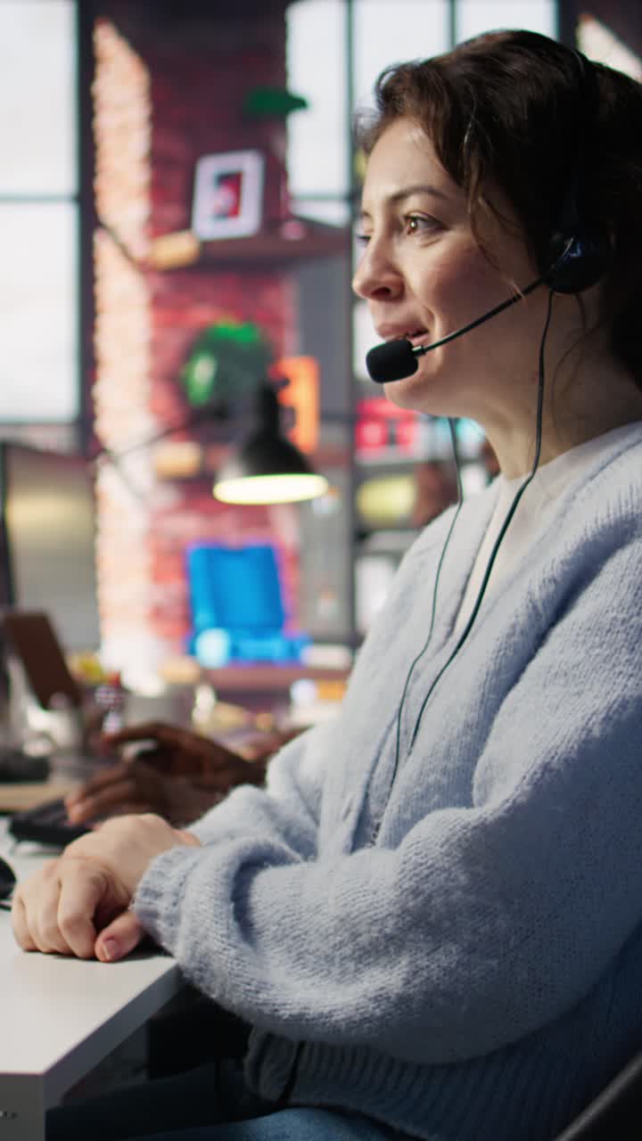 Vertical video Happy call center agent in office helping customers by answering questions