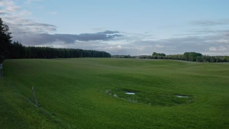 Verdant-Field-At-Sunset-In-Warmia,-Poland---aerial-drone-shot