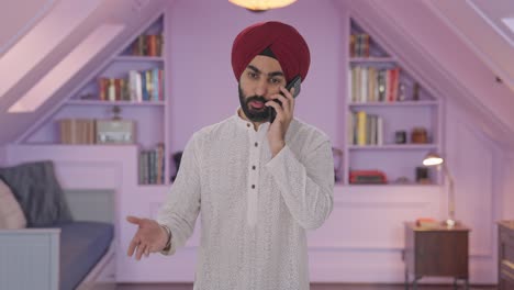 hombre indio sikh enojado gritando a alguien en el teléfono
