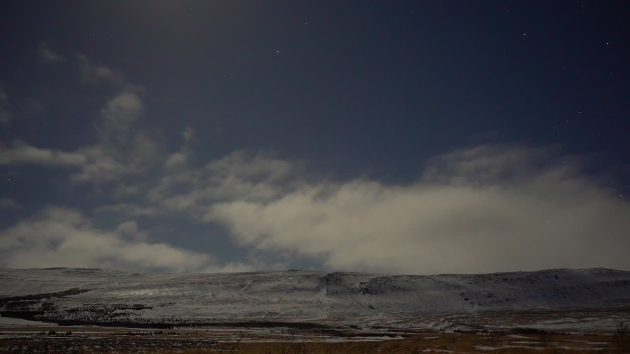 별과 약한 북극광을 배경으로 바람에 움직이는 구름을 보여주는 야간 저속 촬영