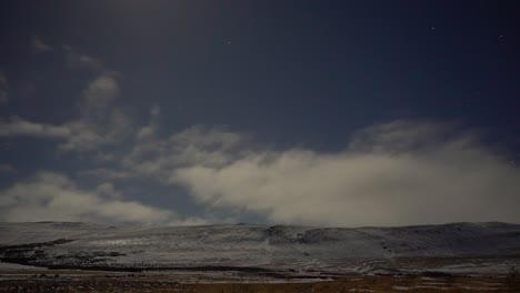 lapsos de tiempo nocturnos que muestran nubes moviéndose en el viento con estrellas y débiles luces del norte en el fondo