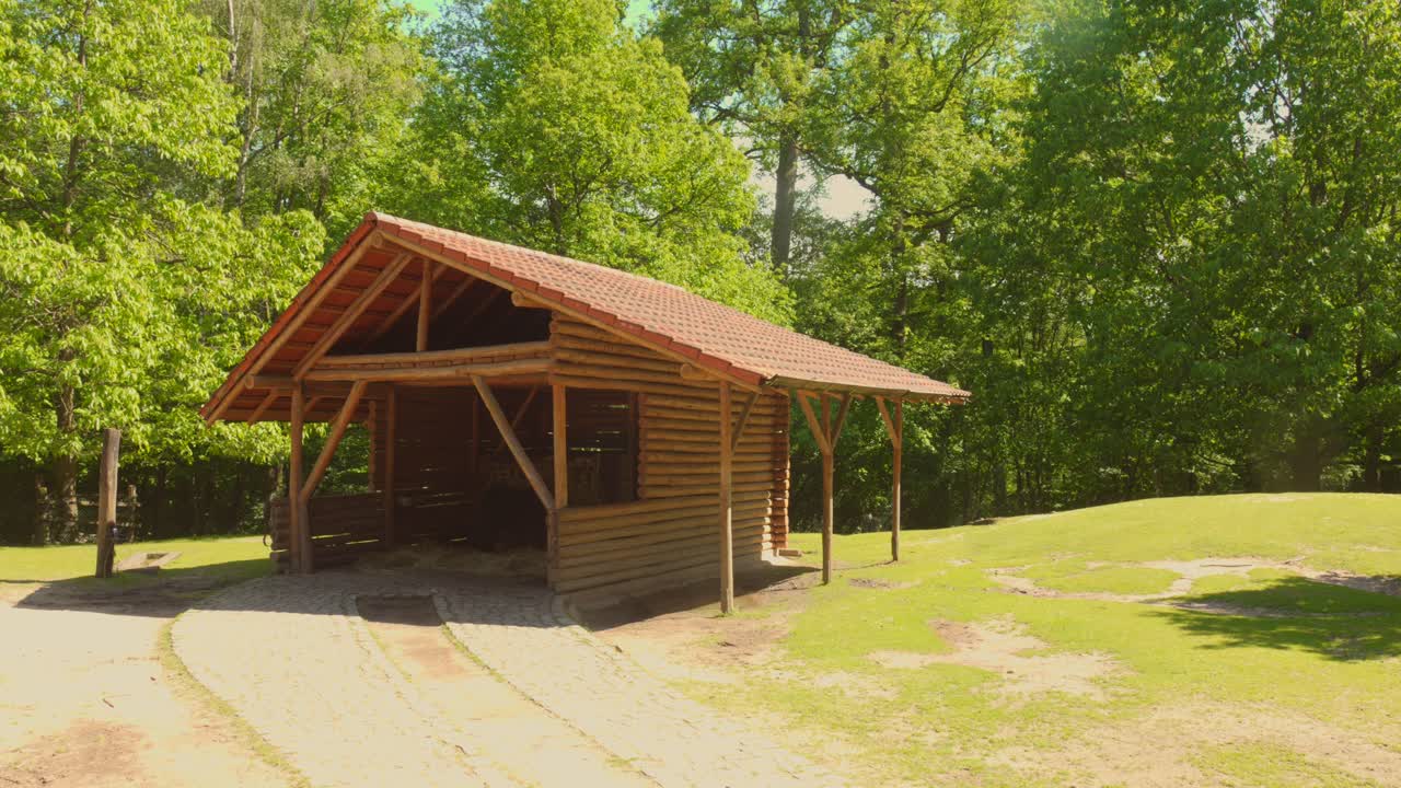 Rustic wooden shelter in Wildpark Sarrebrucken, Germany, used for animals, sunny day
