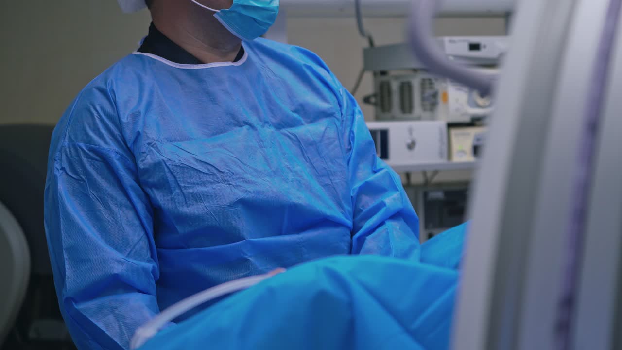 Surgeon during the operation. Professional doctor in medical uniform performs an operation to a patient together with nurse in the hospital.