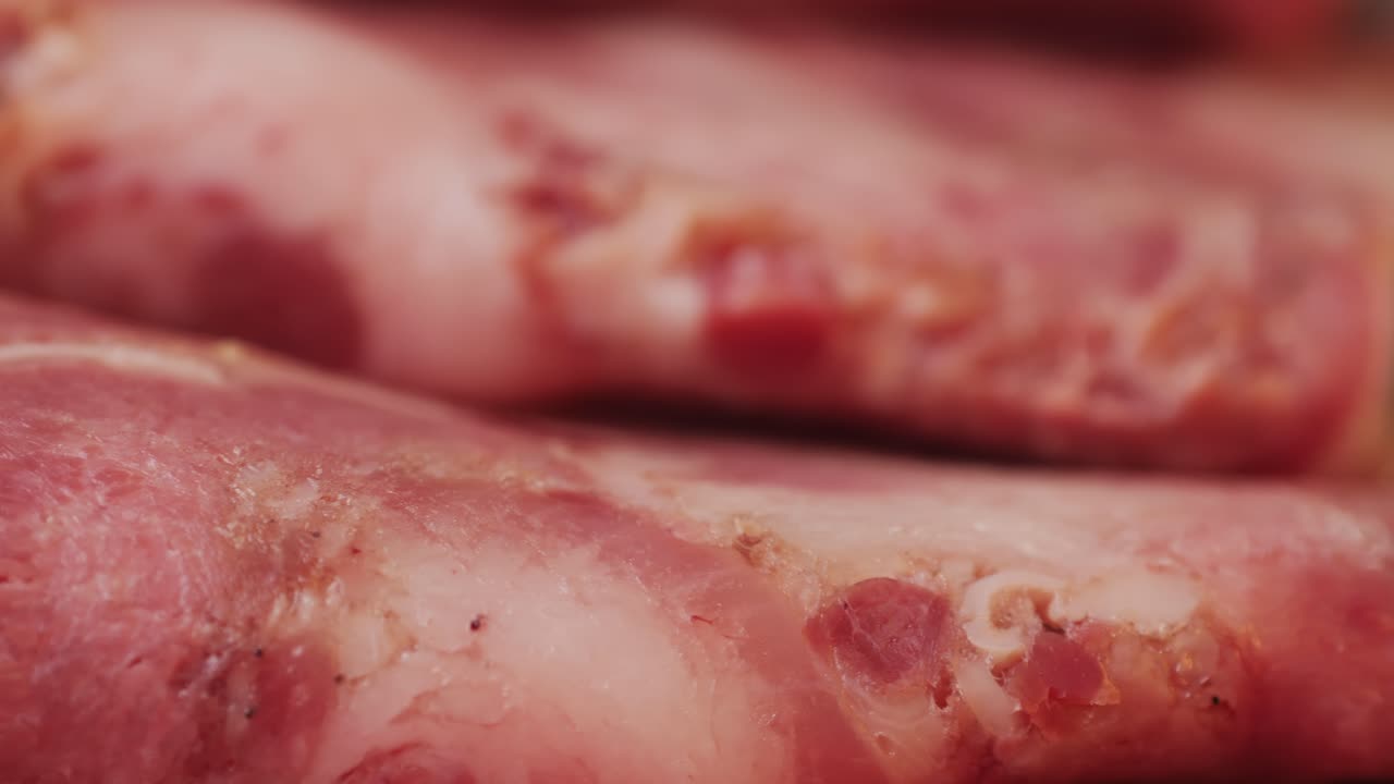 black bull sausage ham, tongue pork dry-cured sausage on a black background, traditional spanish delicatessen food, close up.