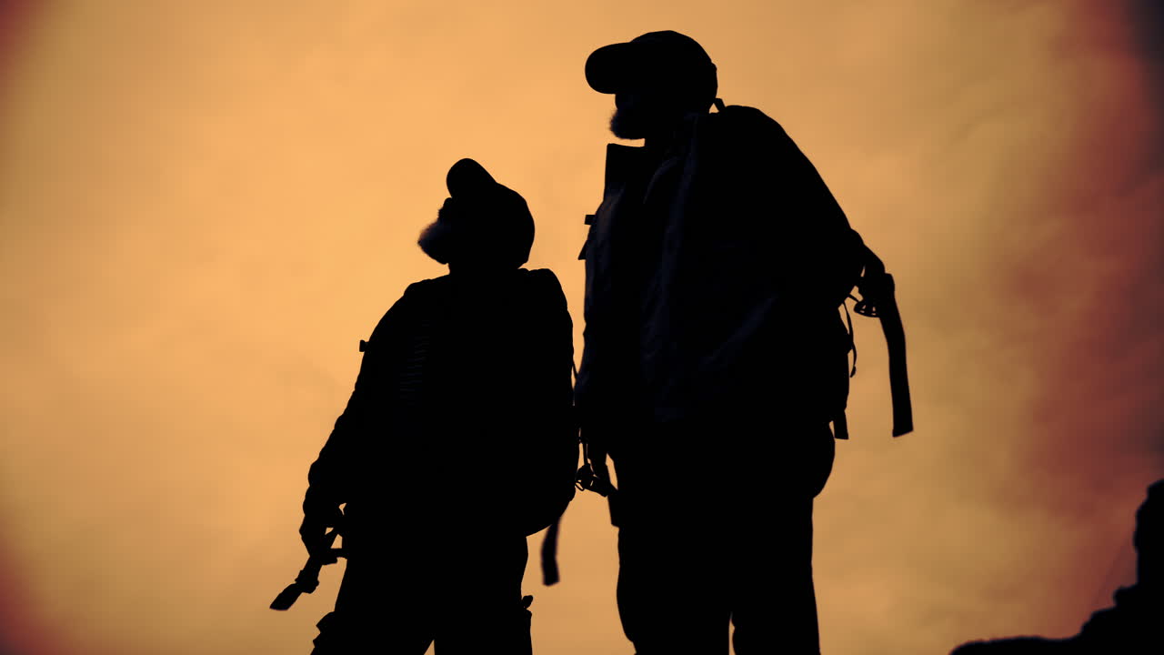 Silhouette of Backpackers at Sunset