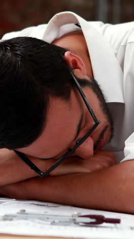 joven arquitecto durmiendo en sus planos