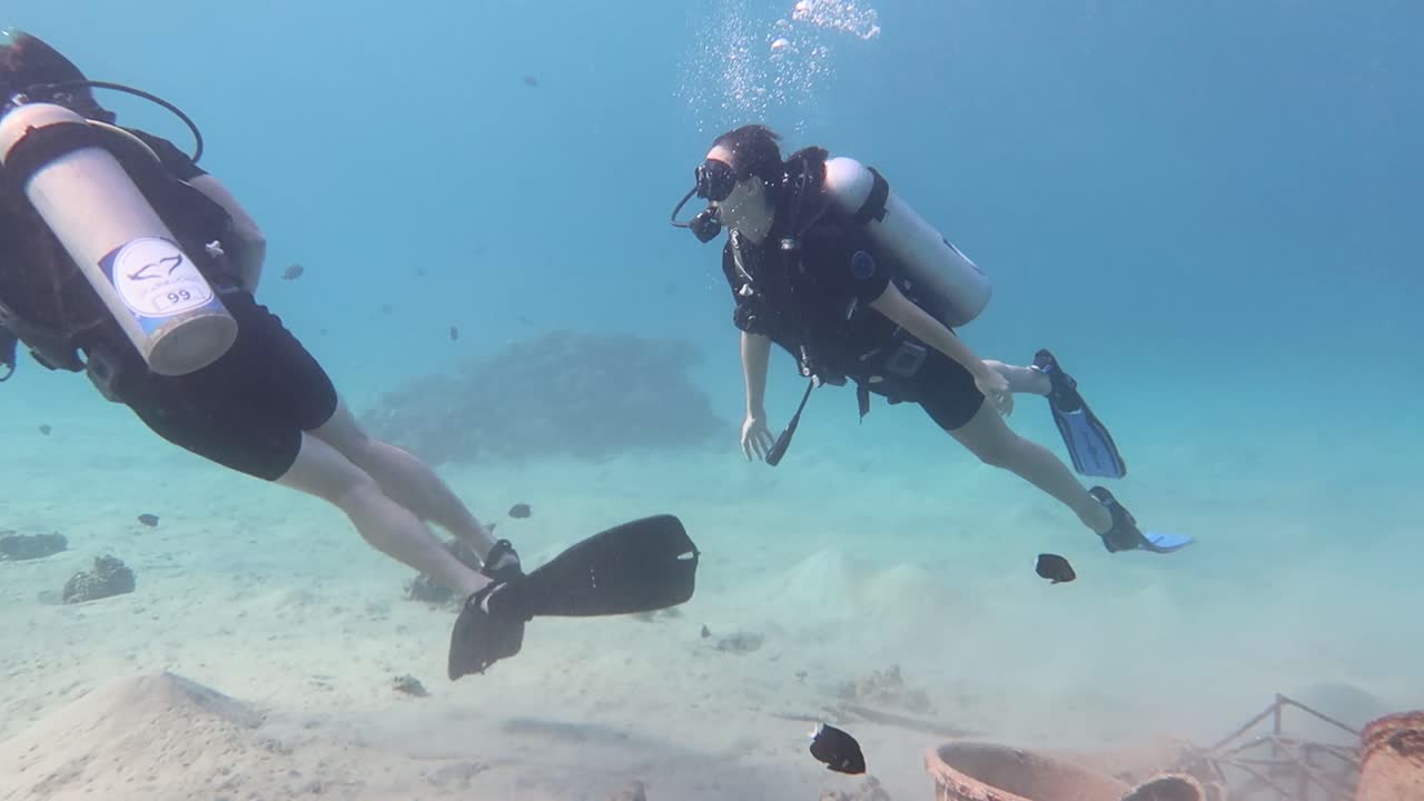 dos buzos filmando una experiencia submarina con un gopro, nadando alrededor del fondo del océano en el mediterráneo.