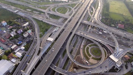 Vista-Aérea-Del-Cruce-De-Carreteras-Con-Tráfico-Urbano-Intenso-Acelerando-En-La-Carretera