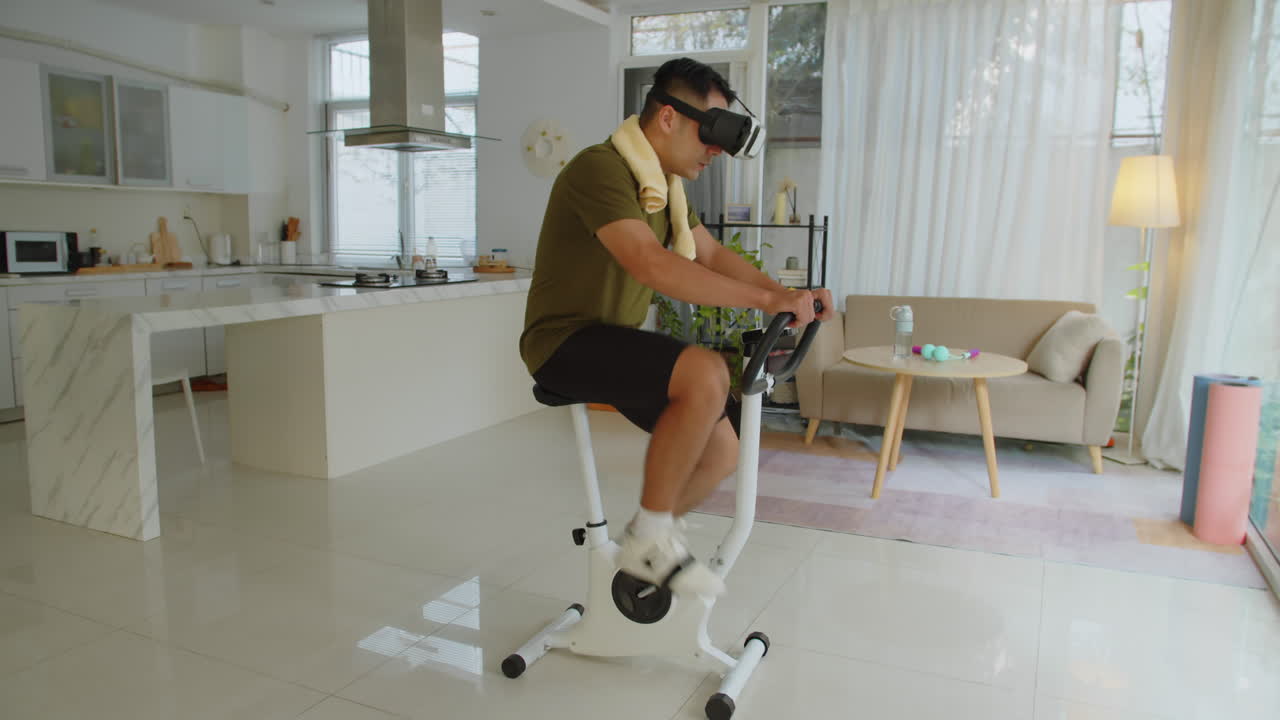 Motivated Sportsman in VR Glasses Cycling on Fitness Bike