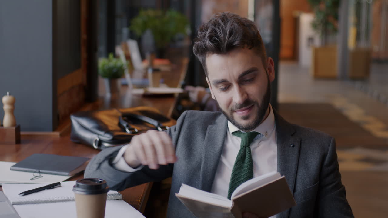 Empresário Lendo e Tomando Café Numa Cafeteria