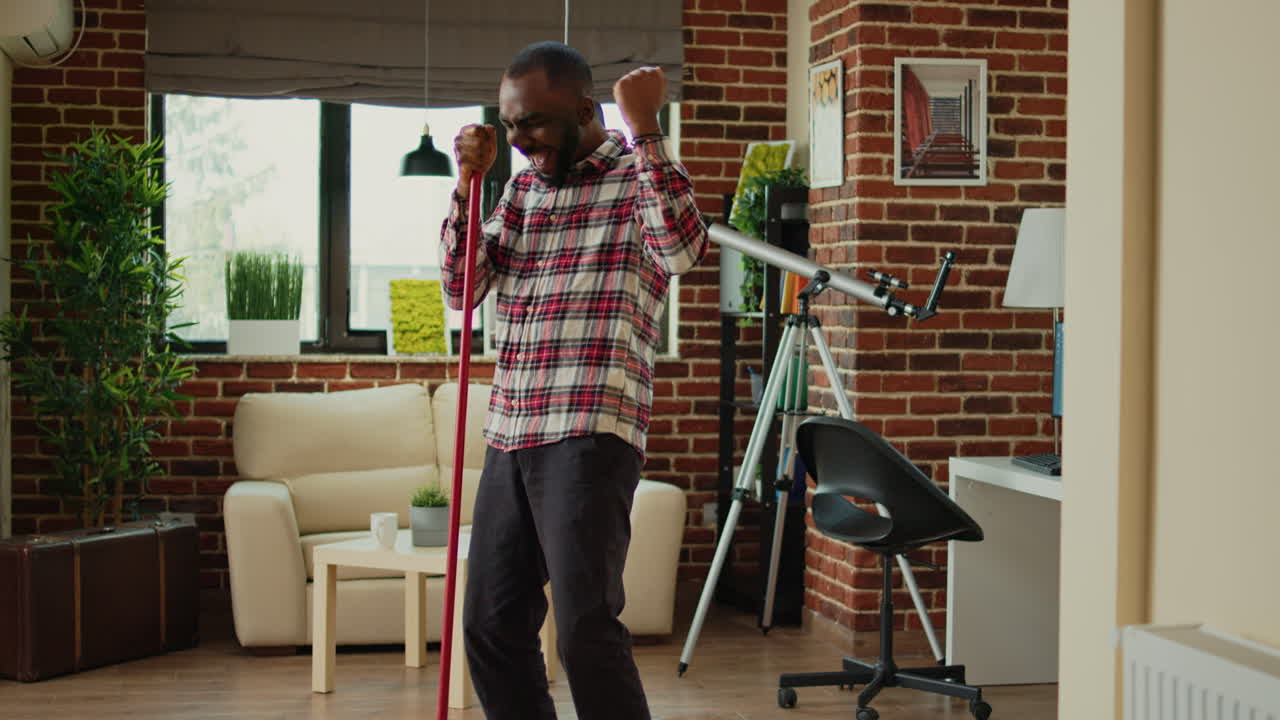 Happy smiling adult mopping living room floor to clean dirt