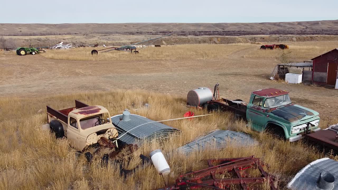 viejos coches y camiones oxidados en un campo sobre crecido en el país cerca de alberta, canadá