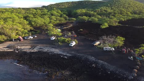 An-aerial-view-of-a-van-parked-for-camping-by-the-ocean