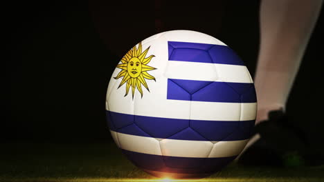 jugador de fútbol pateando la pelota de la bandera de uruguay
