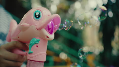 pink dolphin-shaped bubble blower in hand, vibrant outdoor setting, playful and fun