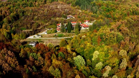 Bunte-Herbstwaldlandschaft,-Rotes-Dach,-Häuser,-Abgelegene-Landstraße