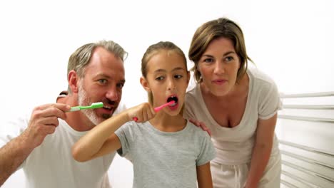 familia cepillándose los dientes en el baño