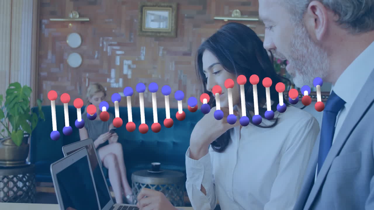 Woman typing on laptop, colleague using smartphone in lounge, showing health tech DNA helix overlay