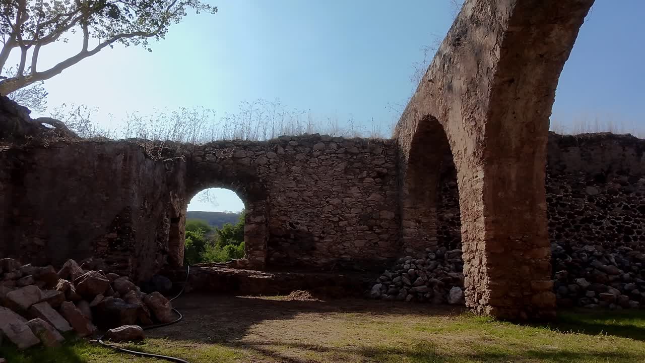 Stone walls and arches of the ruined Hacienda San Jacinto Ixtoluca are bathed in sunlight, showcasing the effects of time and neglect on this historical landmark in Morelos, Mexico