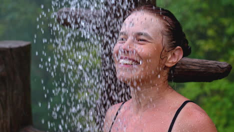 woman enjoying an outdoor waterfall shower