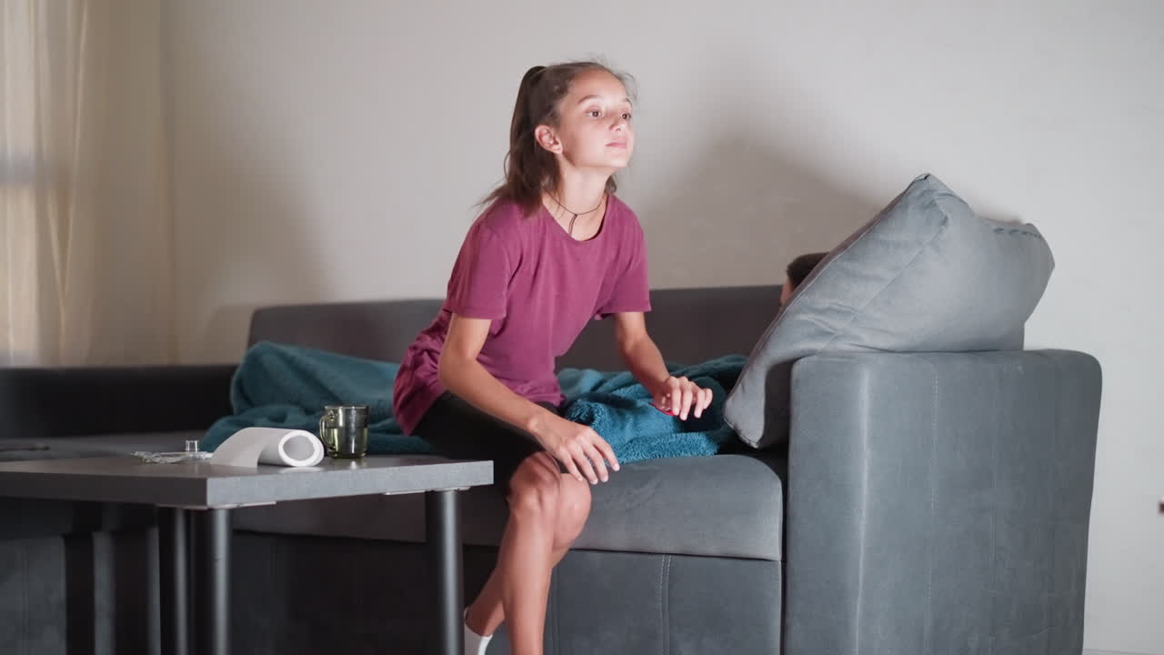 una hermana cariñosa tapa con una manta a su hermano que está dormido, se va, hay medicación en la mesa, cuidados considerados, cuidado entre hermanos, preocupación por la salud, apoyo familiar, curación