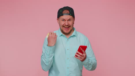 man use mobile cell phone and plastic credit bank card browsing say wow yes found out great big win