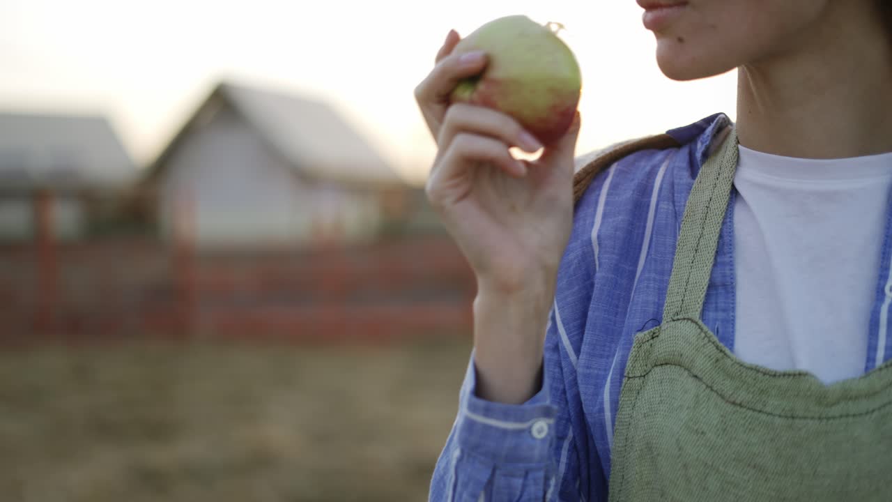 mujer joven mordiendo una manzana roja madura. alimentos orgánicos y concepto de jardinería