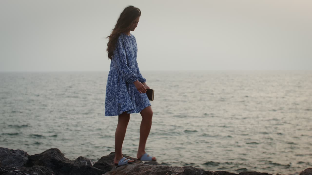 mujer caminando por la playa al atardecer