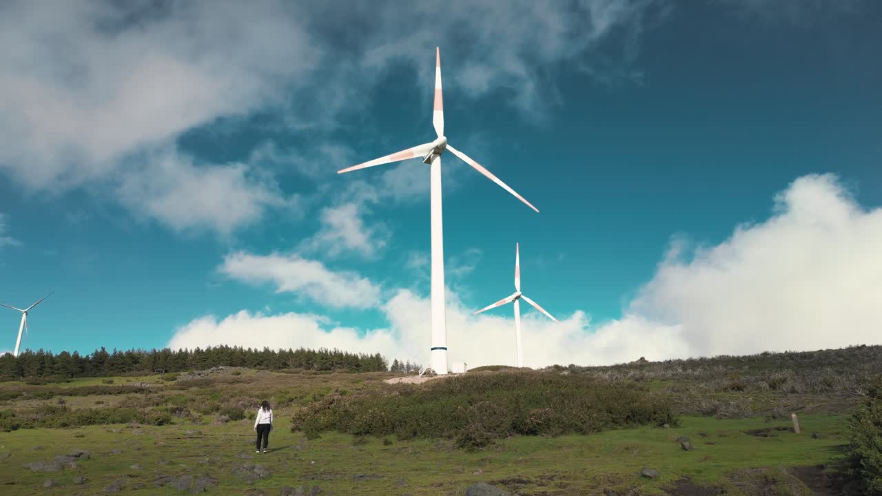 Woman walking near the wind turbines in Fanal, Madeira island, Portugal
