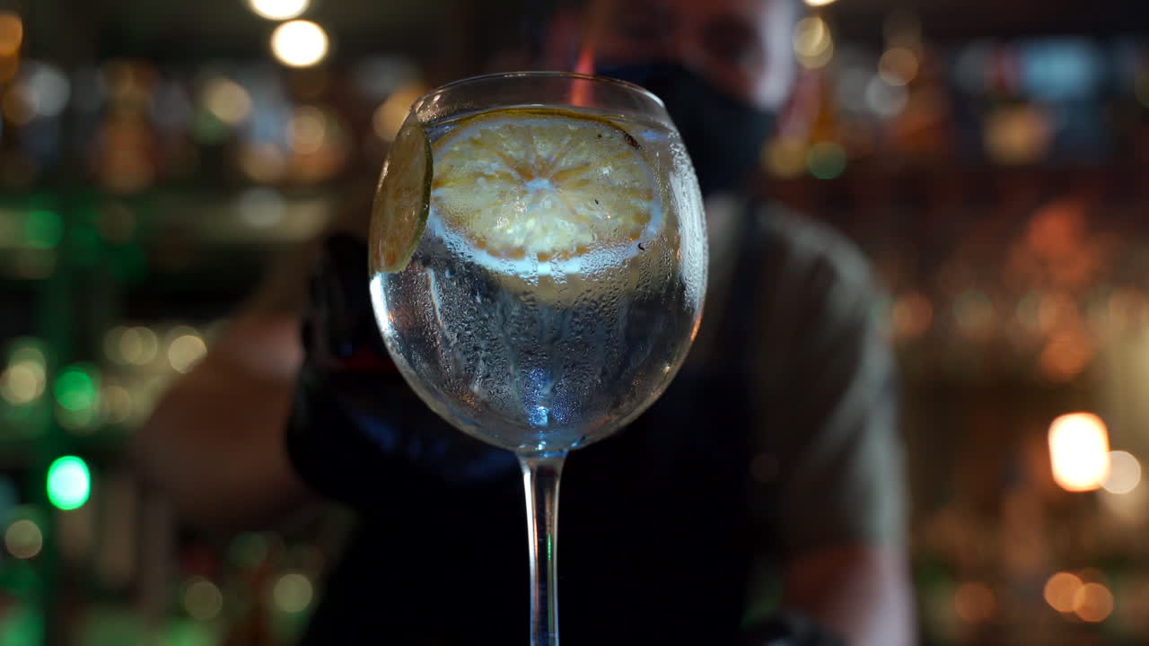 barista fumante fiammeggiante rotante sfondo di bar notturno tonico vodka agli agrumi