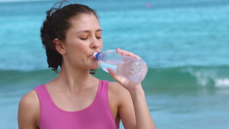 mujer en forma bebiendo una botella de agua