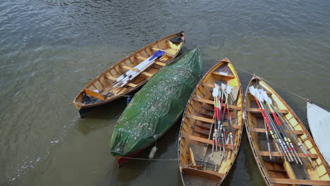 Rowboats-moored-in-River-Thames-await-rental-customers,-Richmond